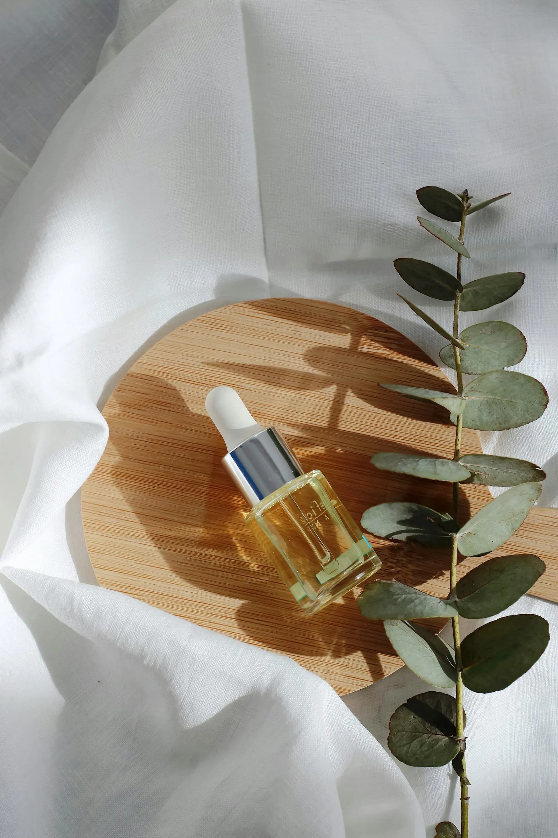 Glass bottle of oil with eucalyptus leaves