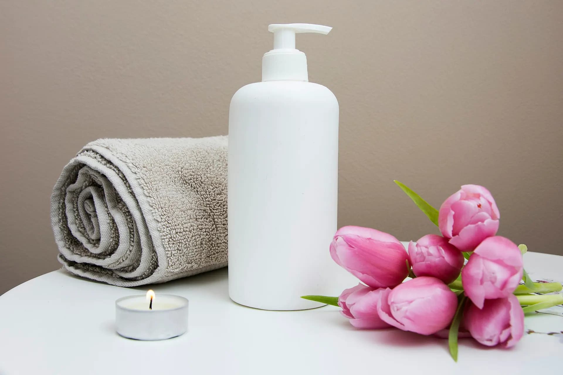 Pump bottle next to a towel and tulips