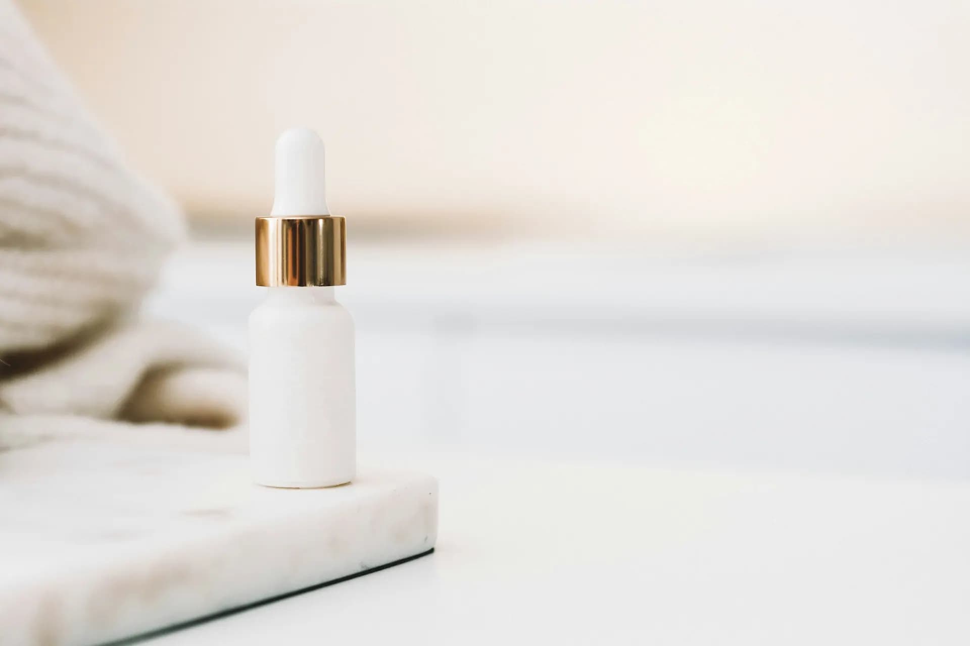 White dropper bottle on marble
