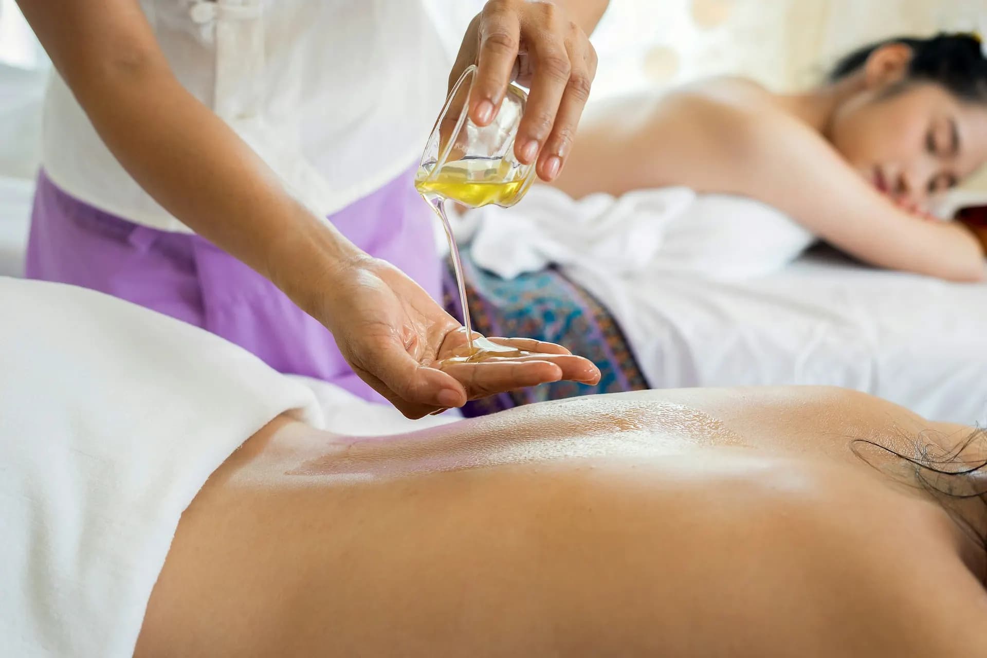 Therapist pouring massage oil during a treatment